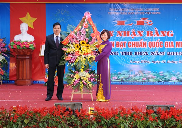 Đ/c Hiệu trường nhận lẵng hoa chúc mừng từ đ/c Chủ tịch UBND phường Giang Biên.